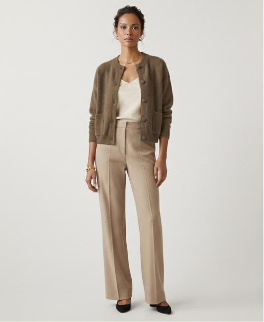 Woman wearing a brown cardigan and beige pants on a white background